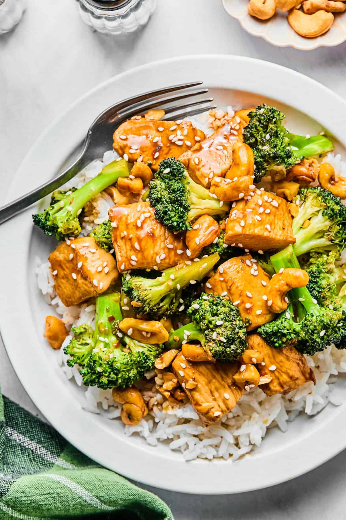 Chicken broccoli stir fry on a bed of rice garnished with sesame seeds.