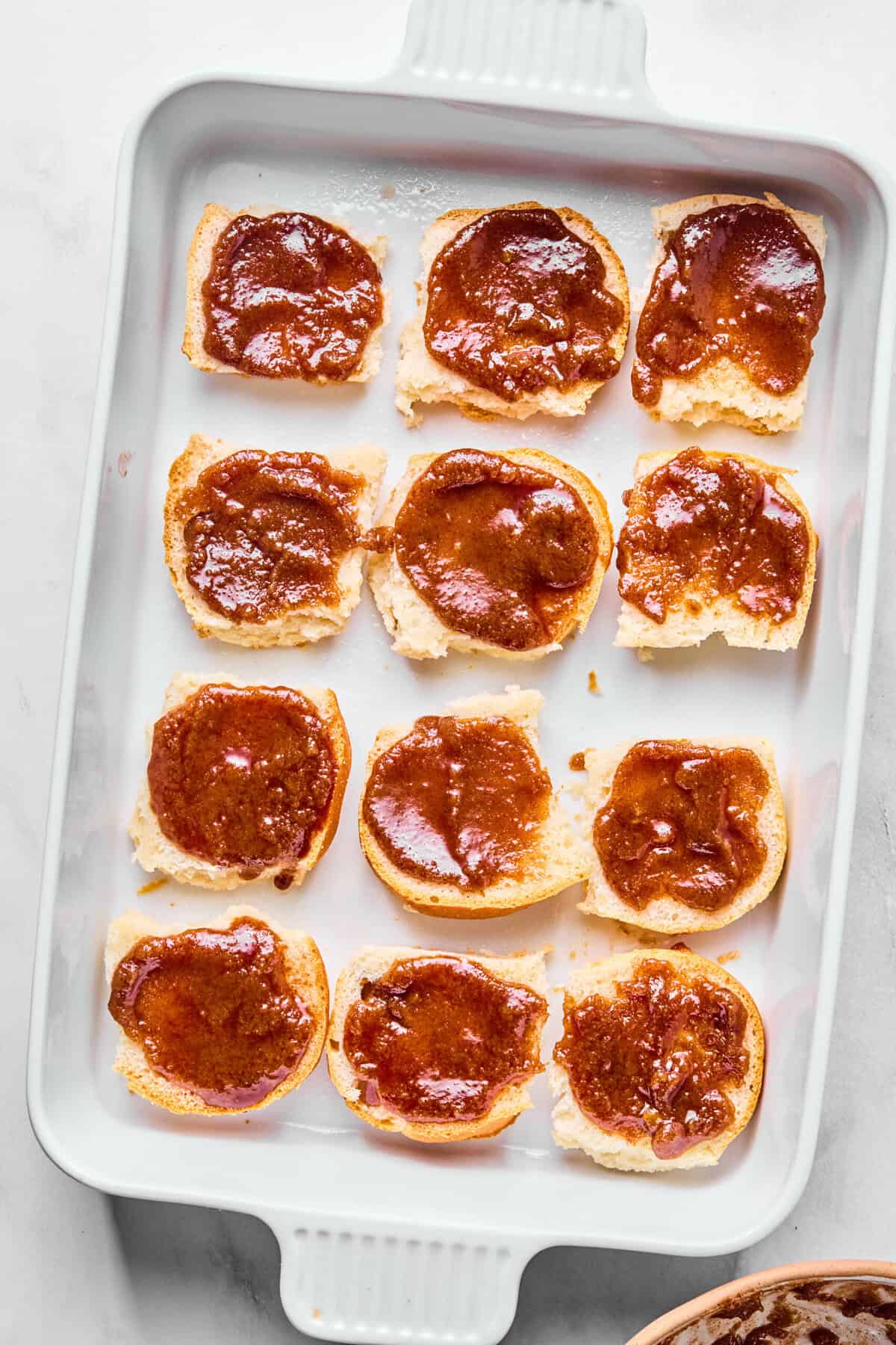 buns topped with cinnamon butter in a baking dish