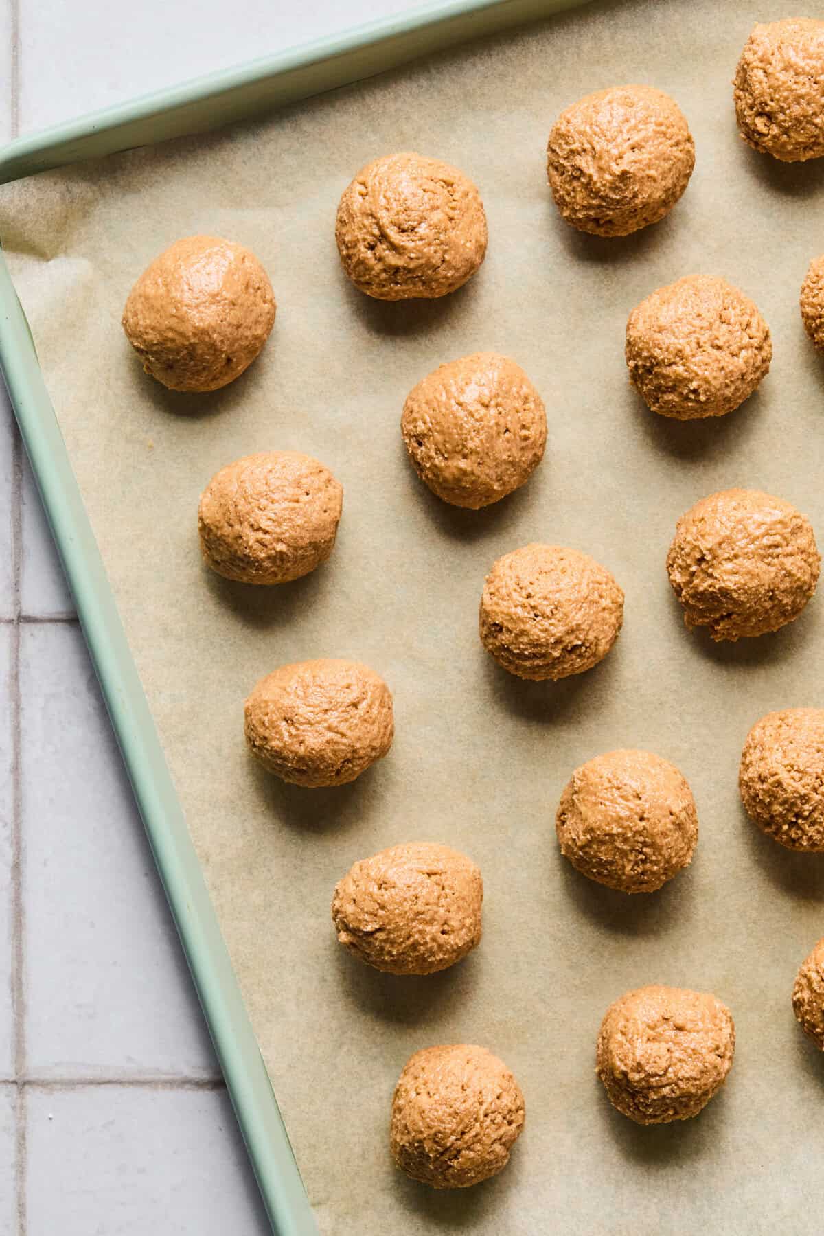 peanut butter balls on a baking sheet lined with parchment paper