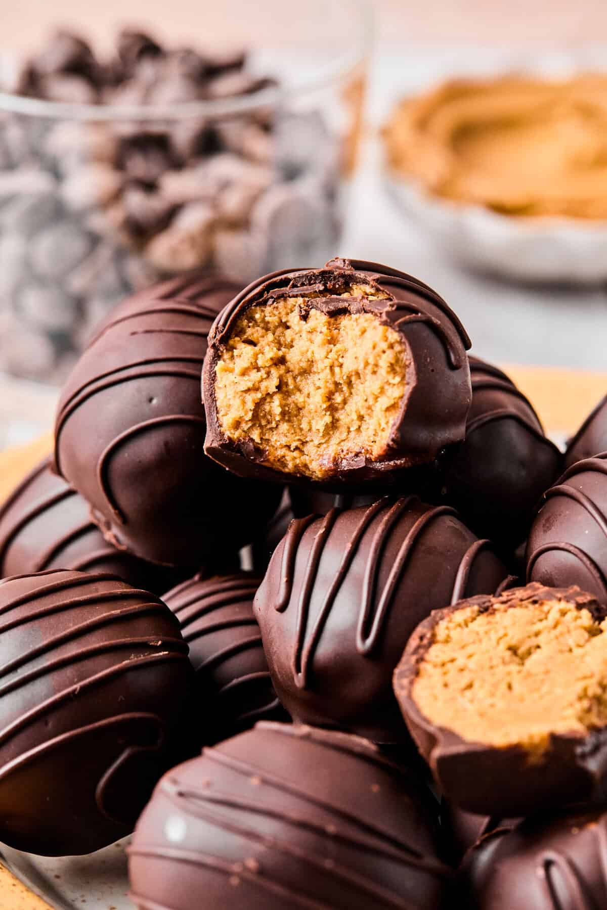 a close-up of a bite taken out of a peanut butter ball which is stacked on top of other ones