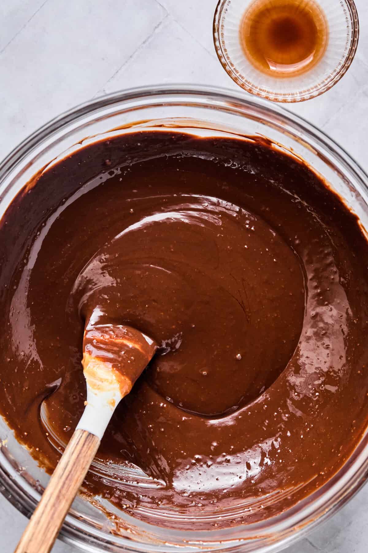 Melted chocolate chips, peanut butter, butter, and vanilla in a glass bowl.