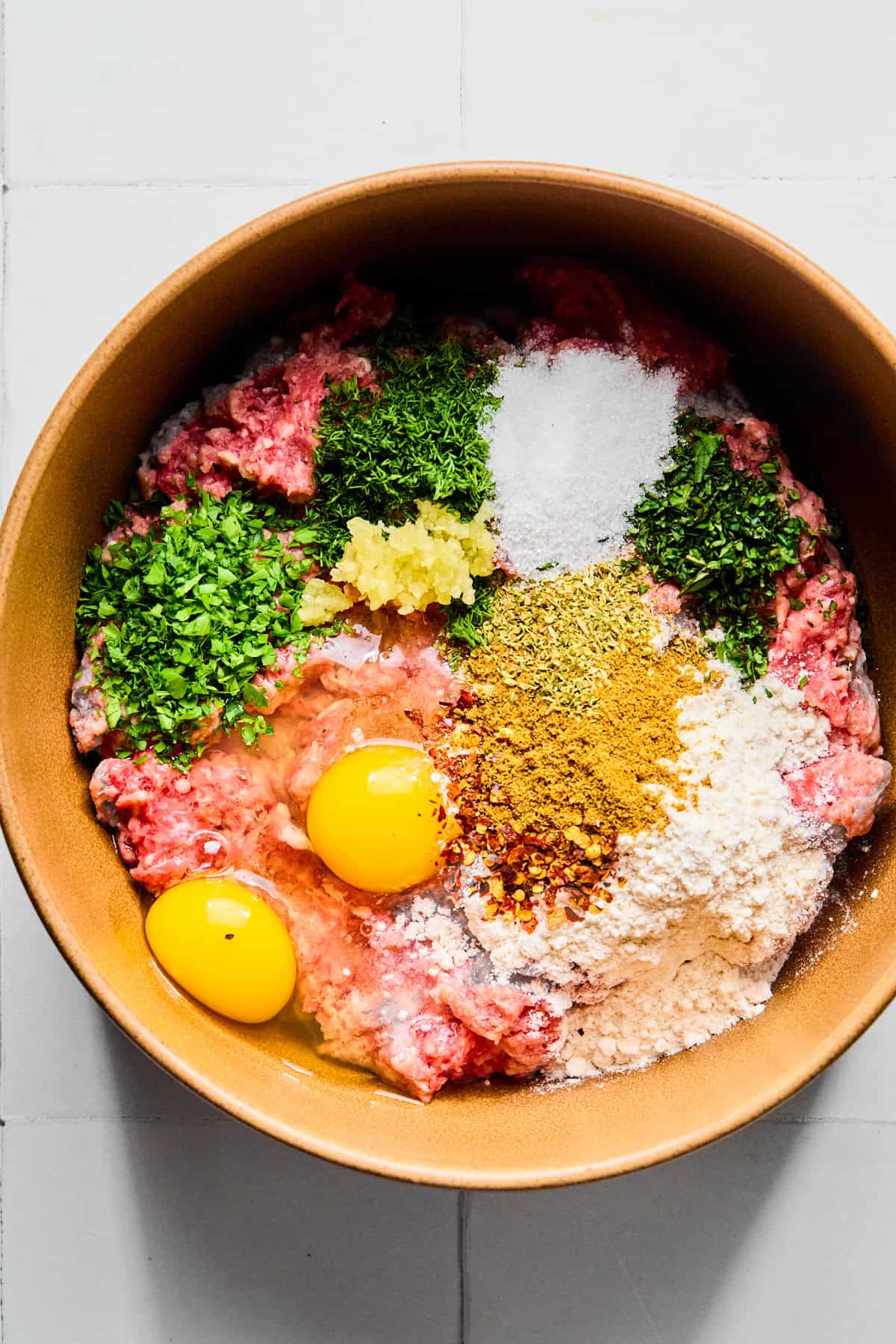 Greek lamb meatball ingredients in a large bowl.