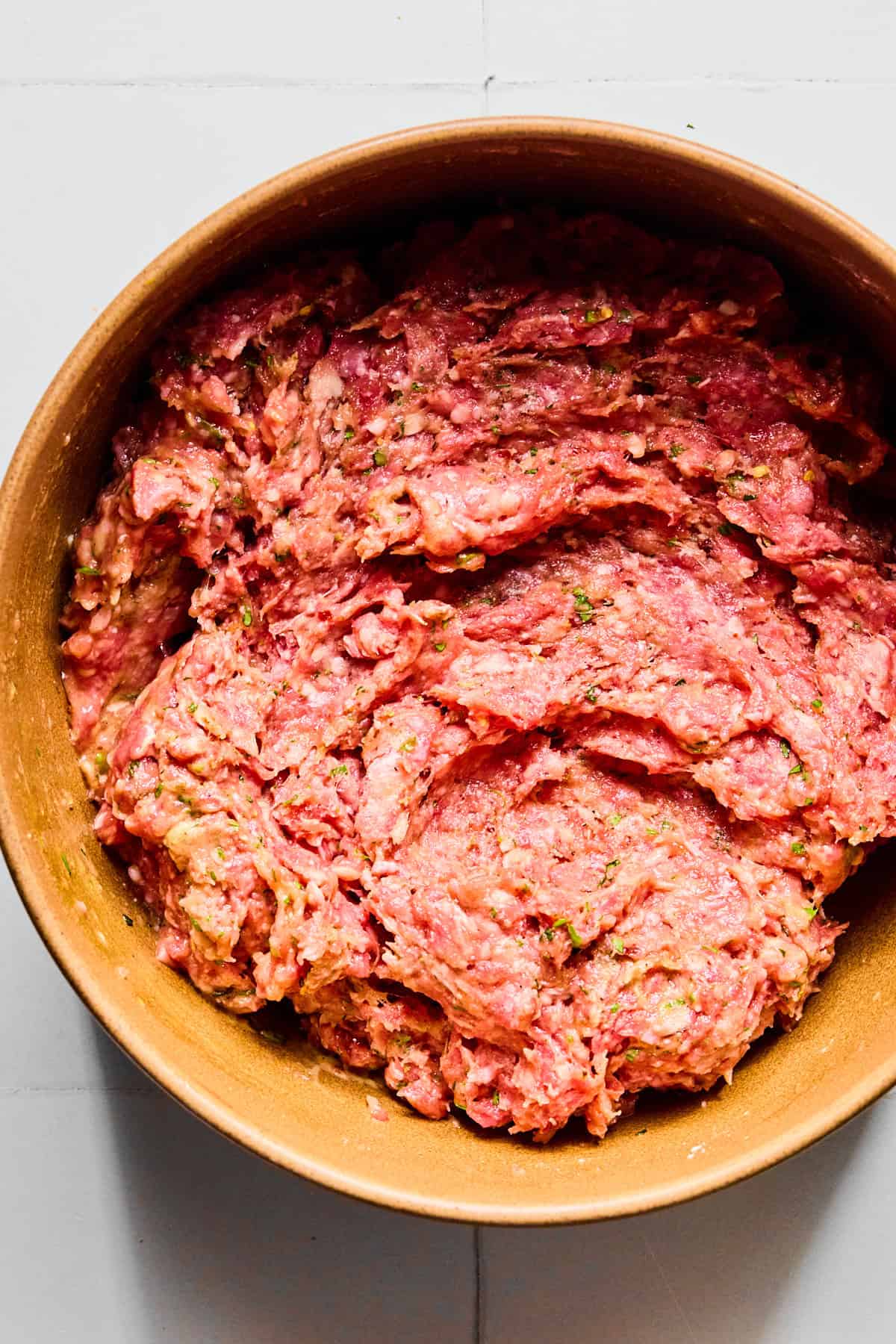 Meatball ingredients in a large bowl mixed together so that everything is evenly incorporated.