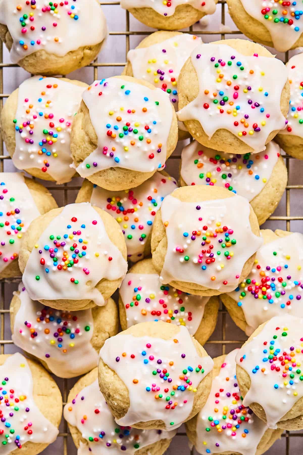 Close-up of gluten free Italian wedding cookies stacked on a wire cooling rack.