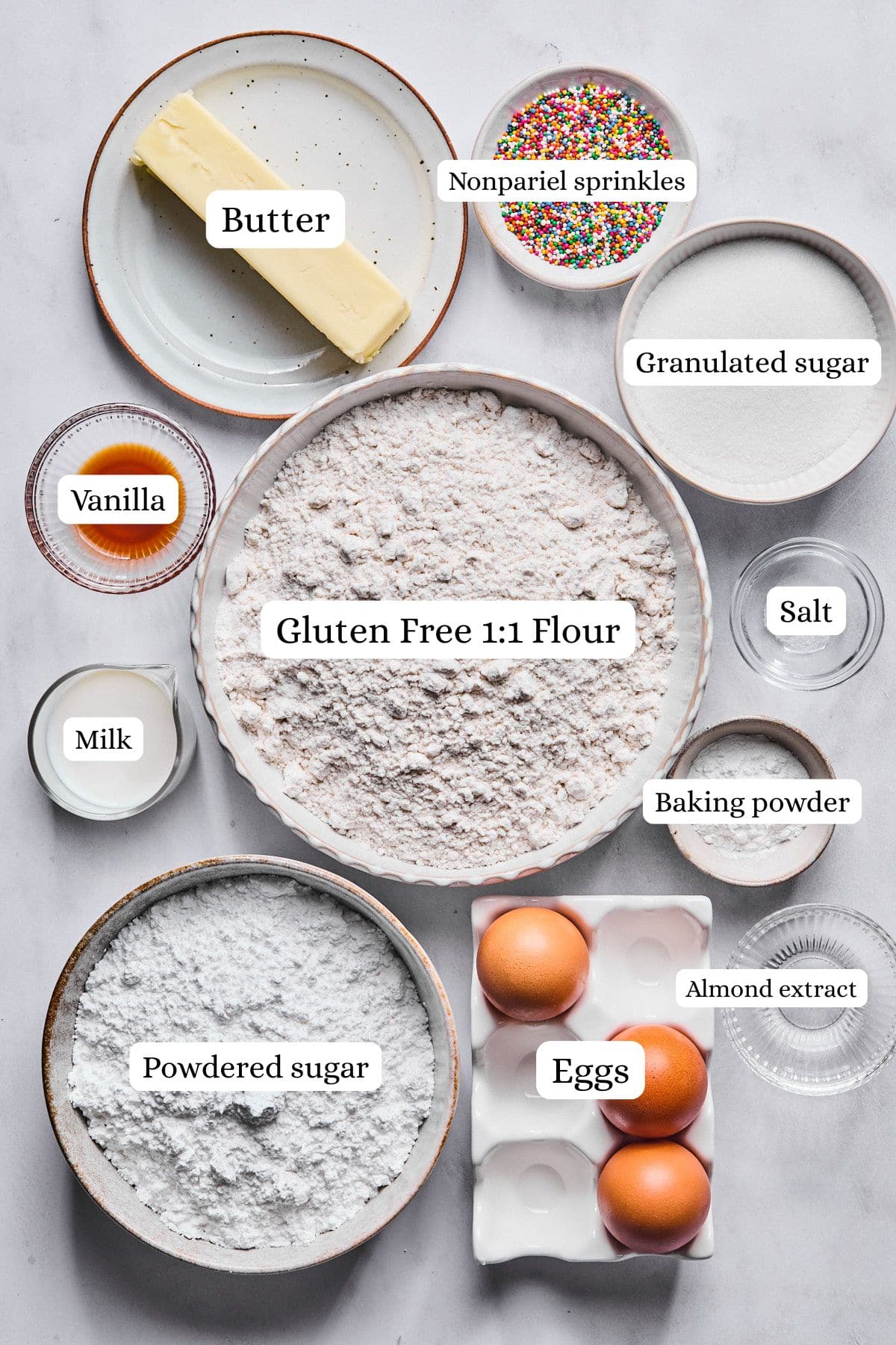 Gluten free Italian wedding cookies ingredients labeled and laid out on a light gray countertop.