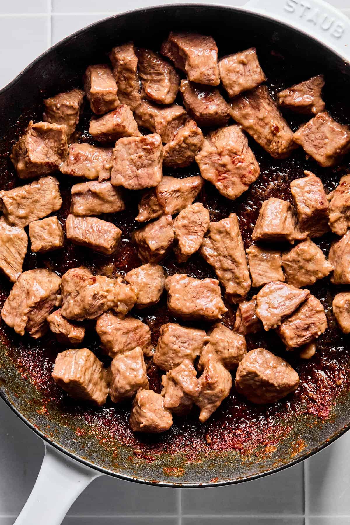 Stew meat in a skillet seared on all sides.