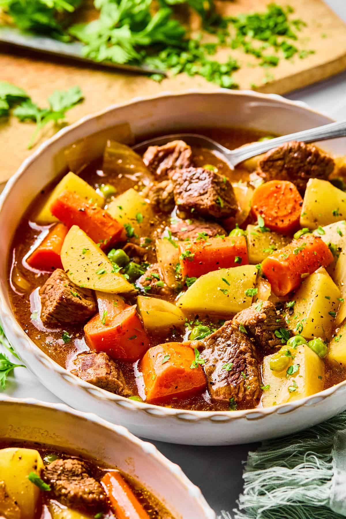 Close-up of a bowl of slow cooker beef stew with a spoon in it.