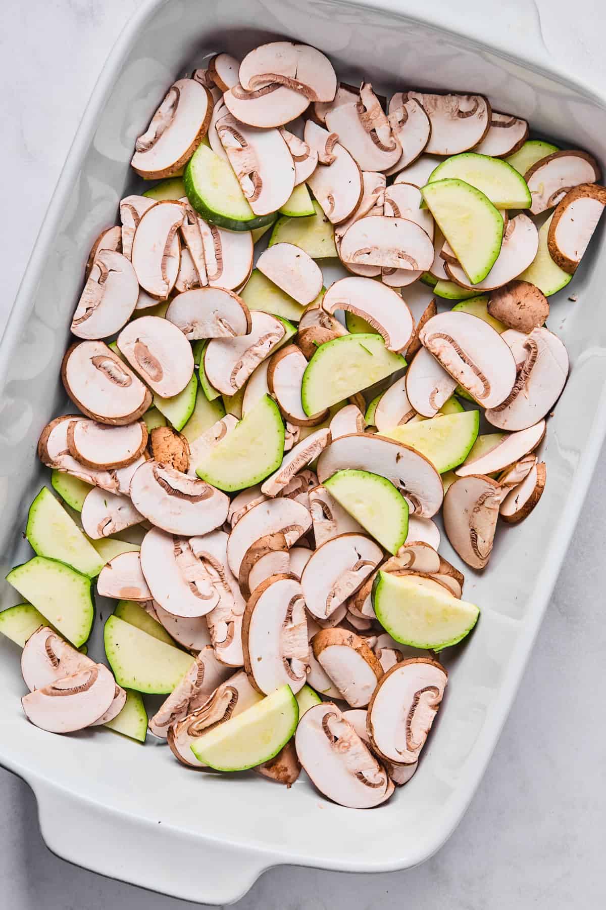 mushrooms and zucchini in a casserole dish