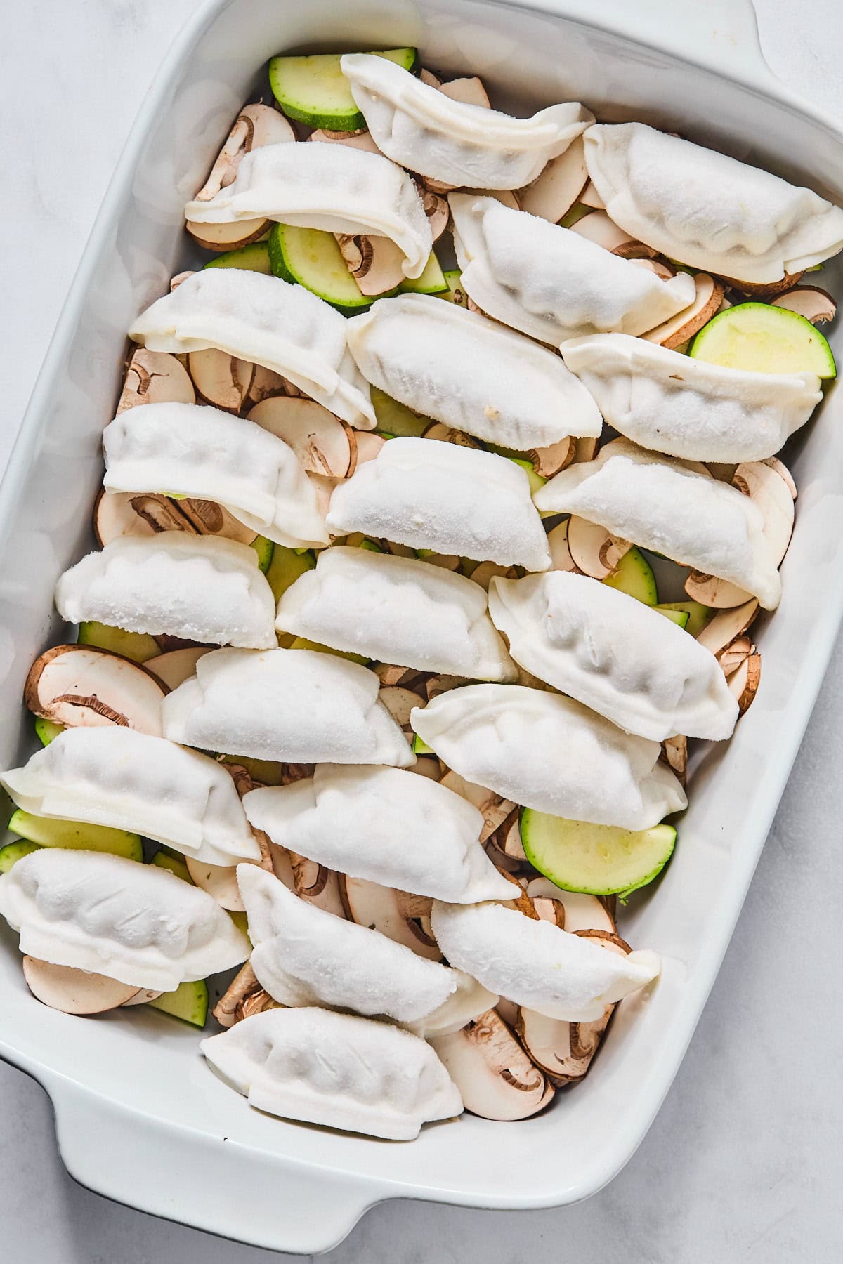 dumplings on top of vegetables in a dish