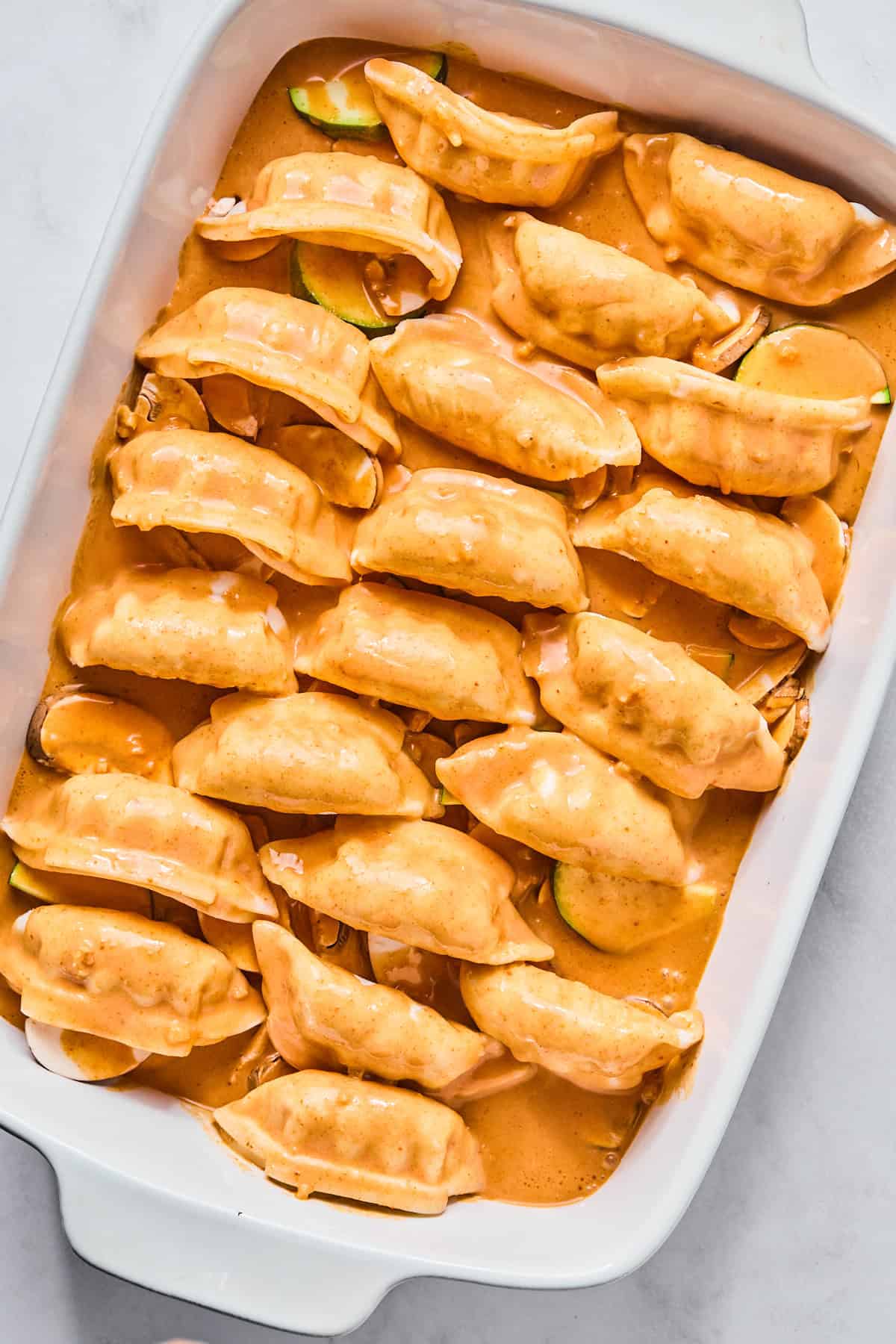 dumplings with red sauce in a casserole dish