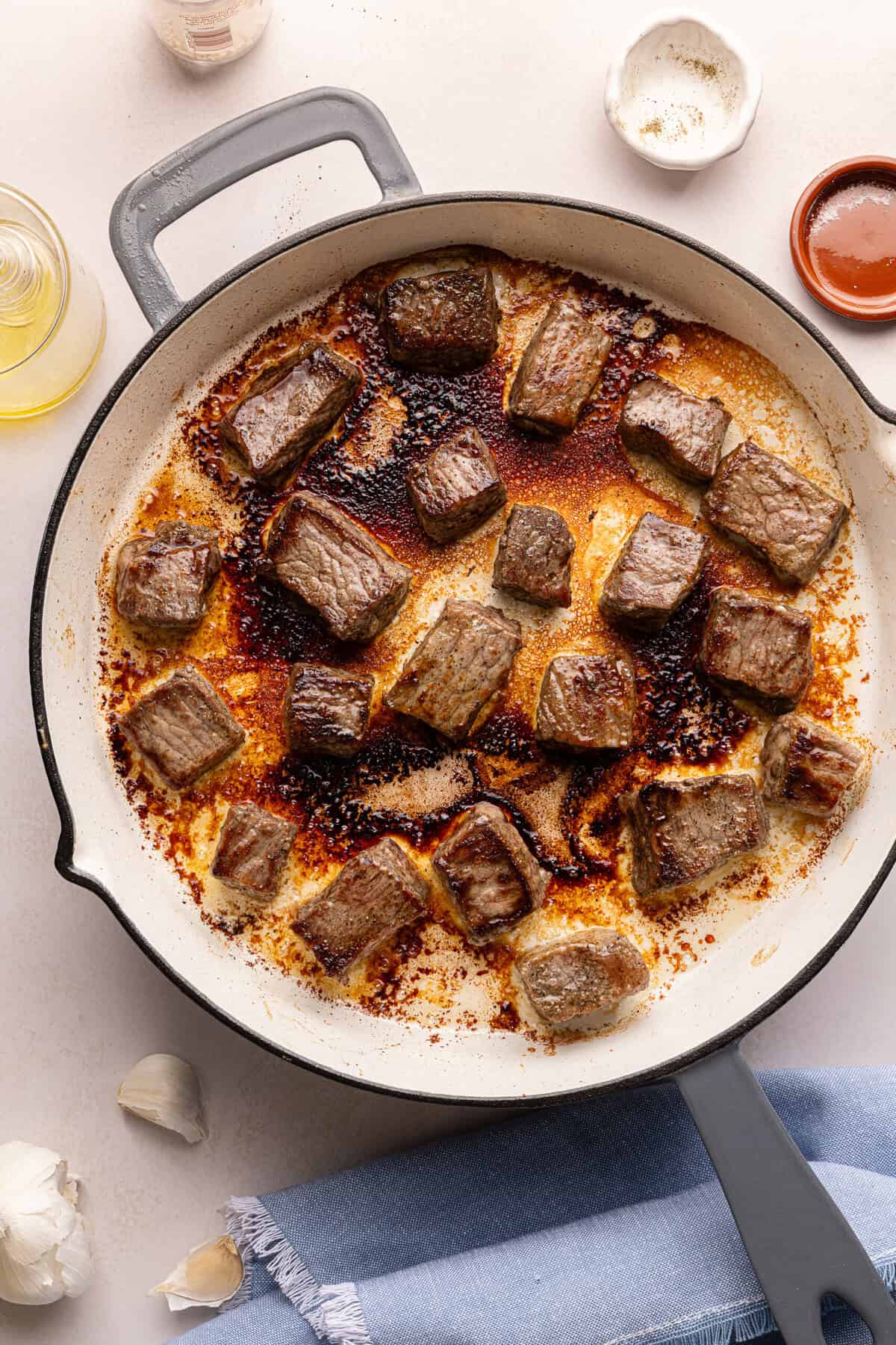 steak bites searing in a pan