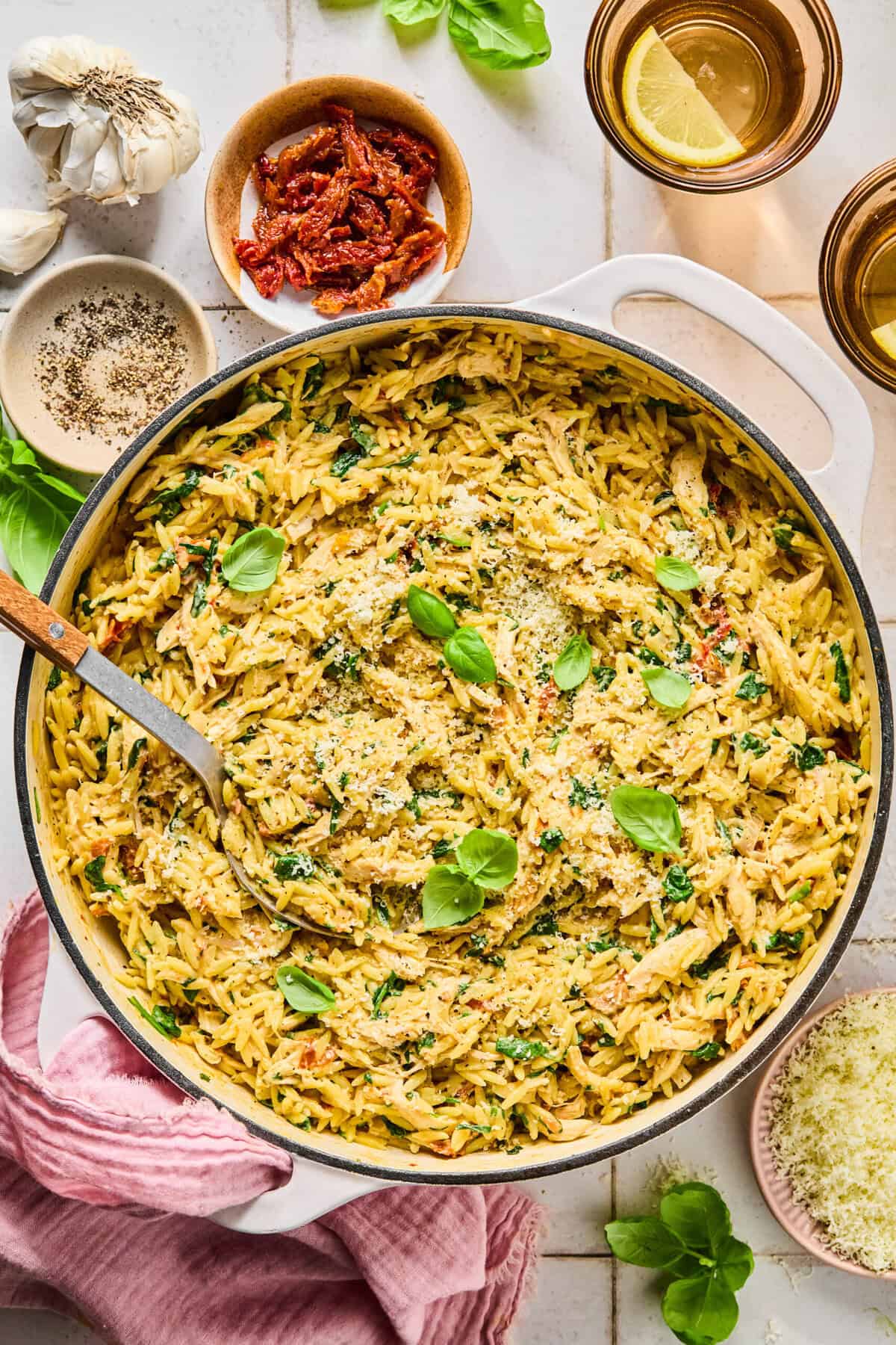 One-pan marry me chicken orzo in a skillet with ingredients arranged around the pan.