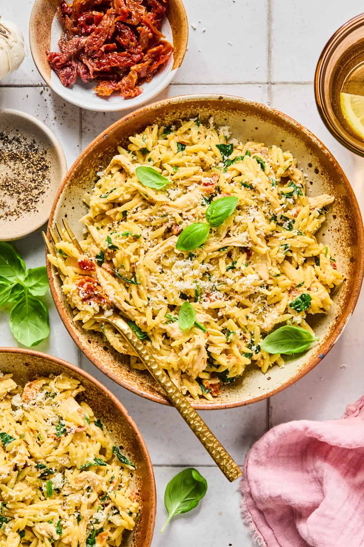 Birds eye view of creamy gluten-free marry me chicken orzo topped with fresh basil and grated parmesan in a bowl.