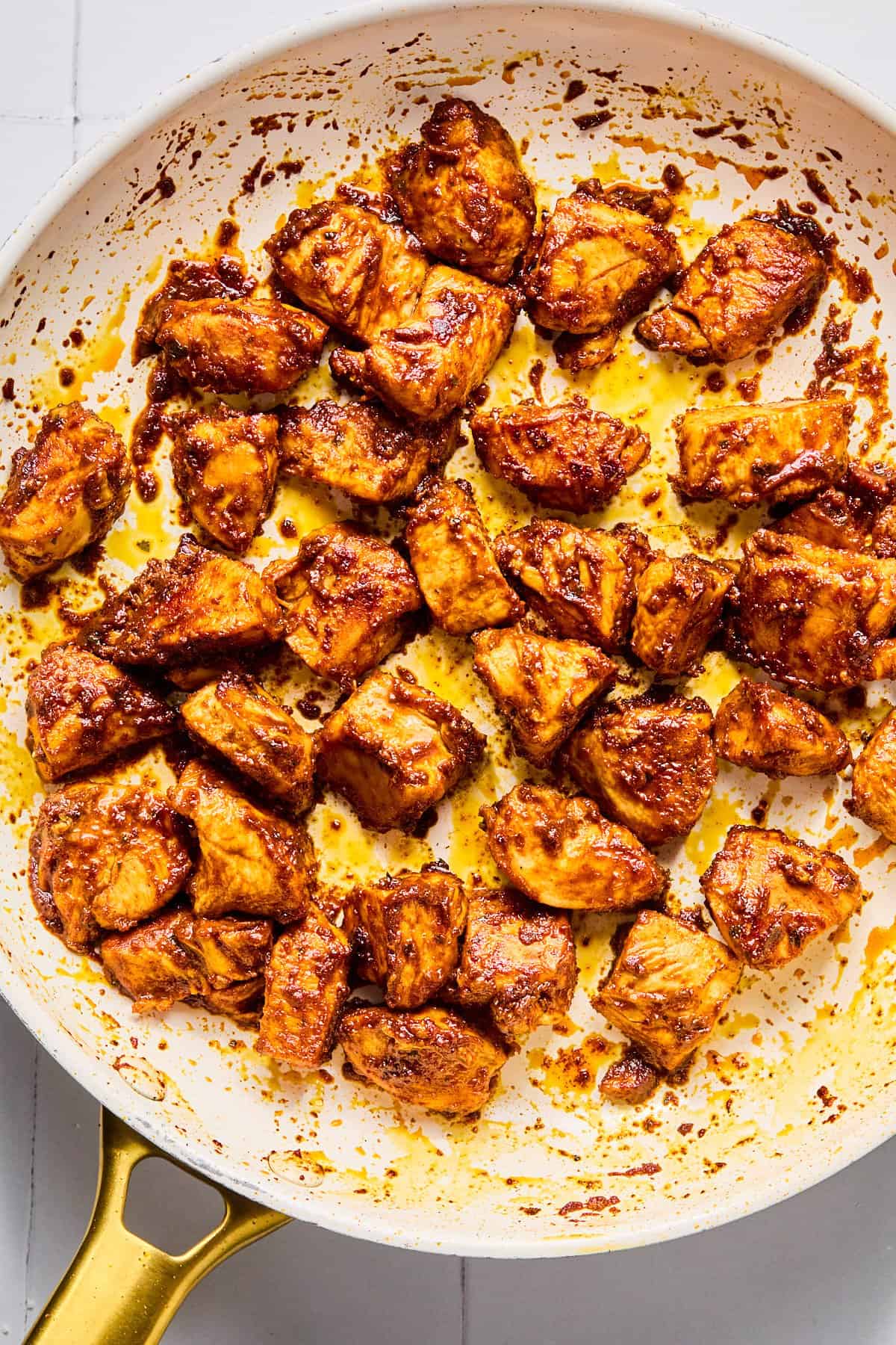 Taco-seasoned chicken breast pieces searing in a hot skillet.
