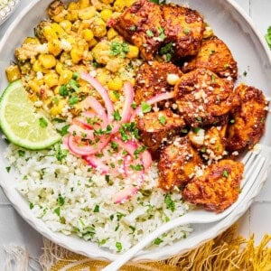 Street corn chicken and rice bowls with a yellow napkin and a fork in the bowl