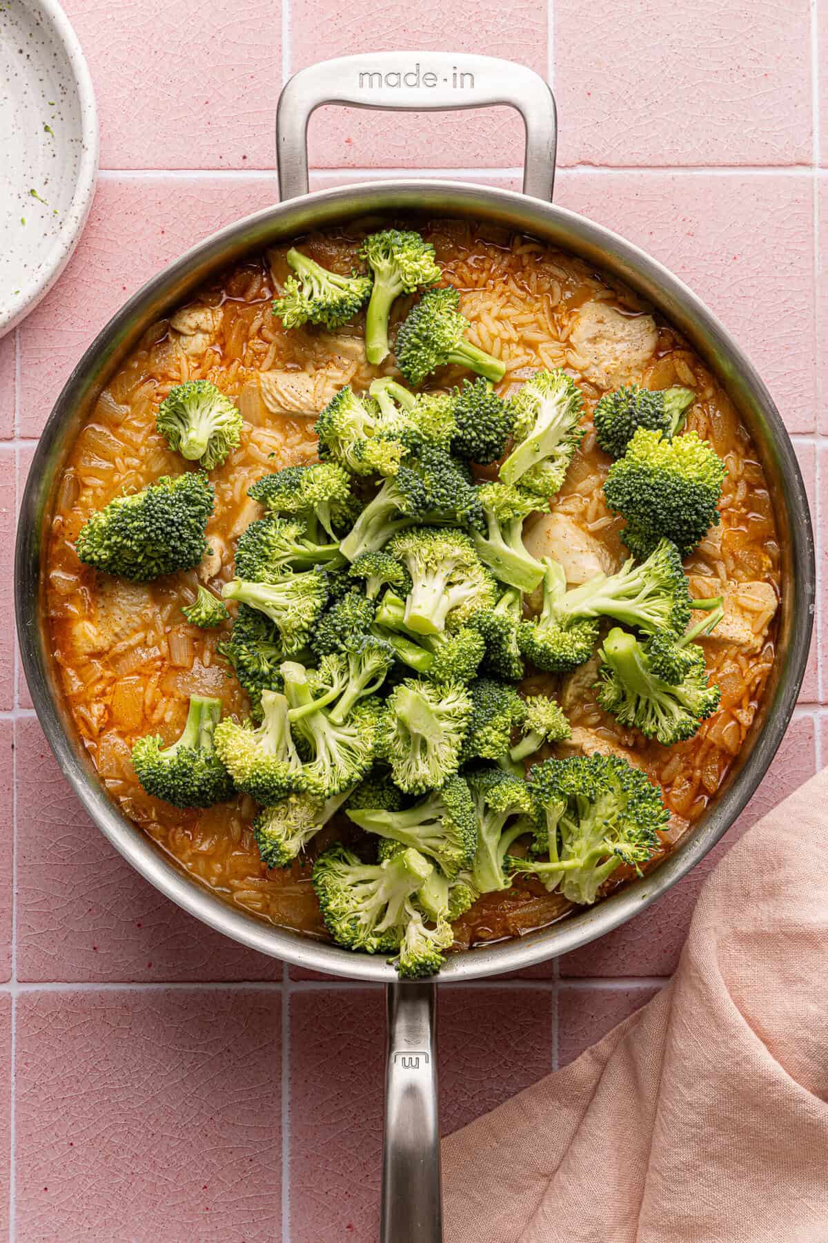 broccoli, broth, chicken and rice in a pan