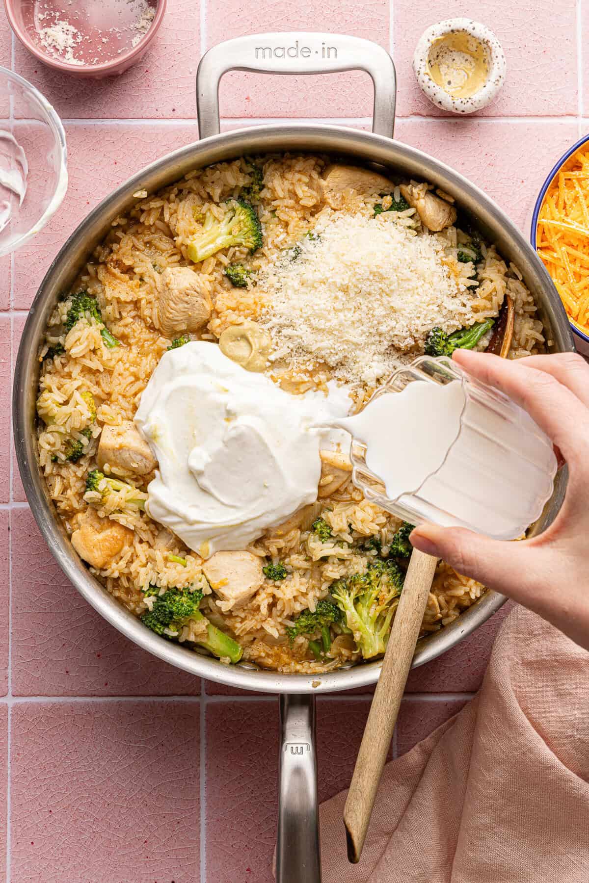 milk and greek yogurt being added to a casserole in a pan