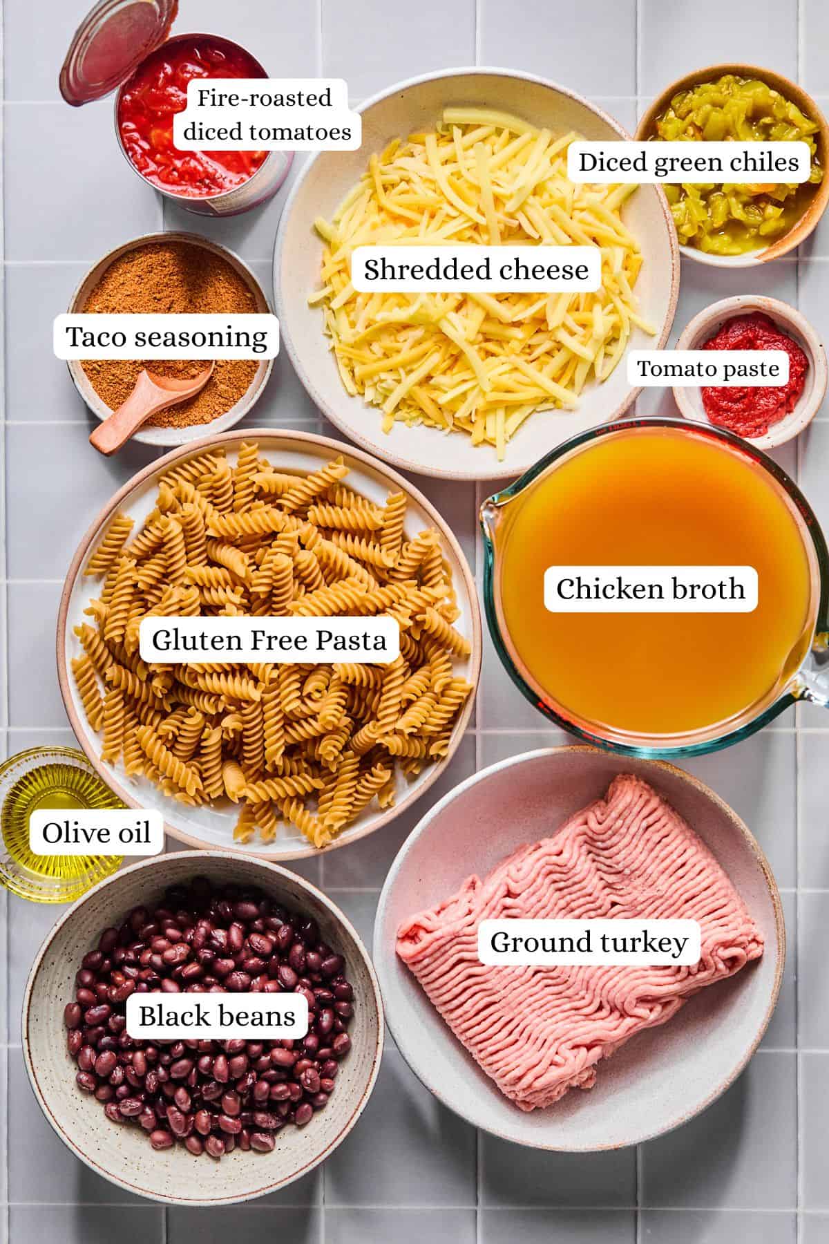 Ingredients for one pot taco pasta arranged in labeled nesting bowls.