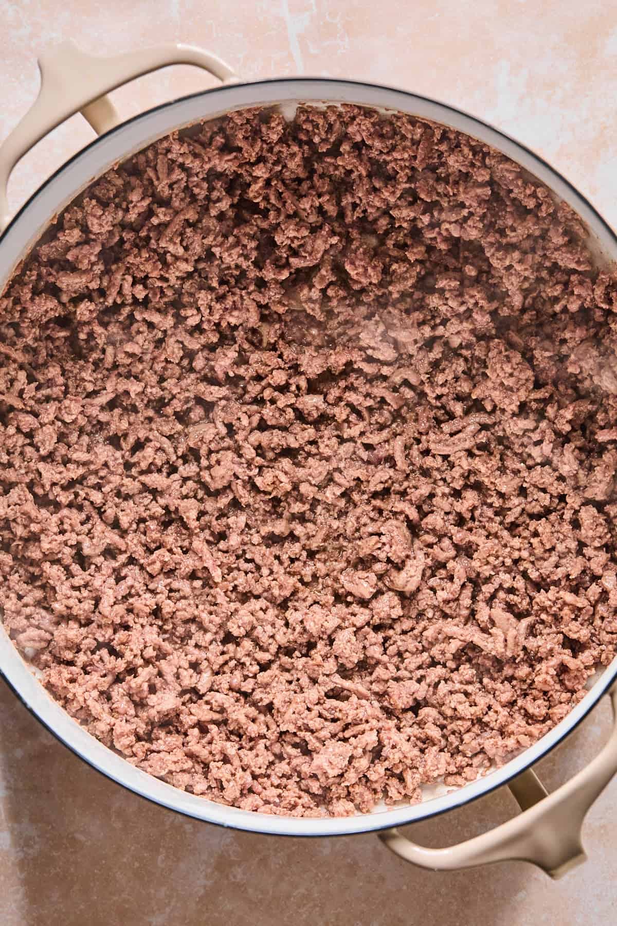 Browning ground beef in a Dutch Oven with olive oil.