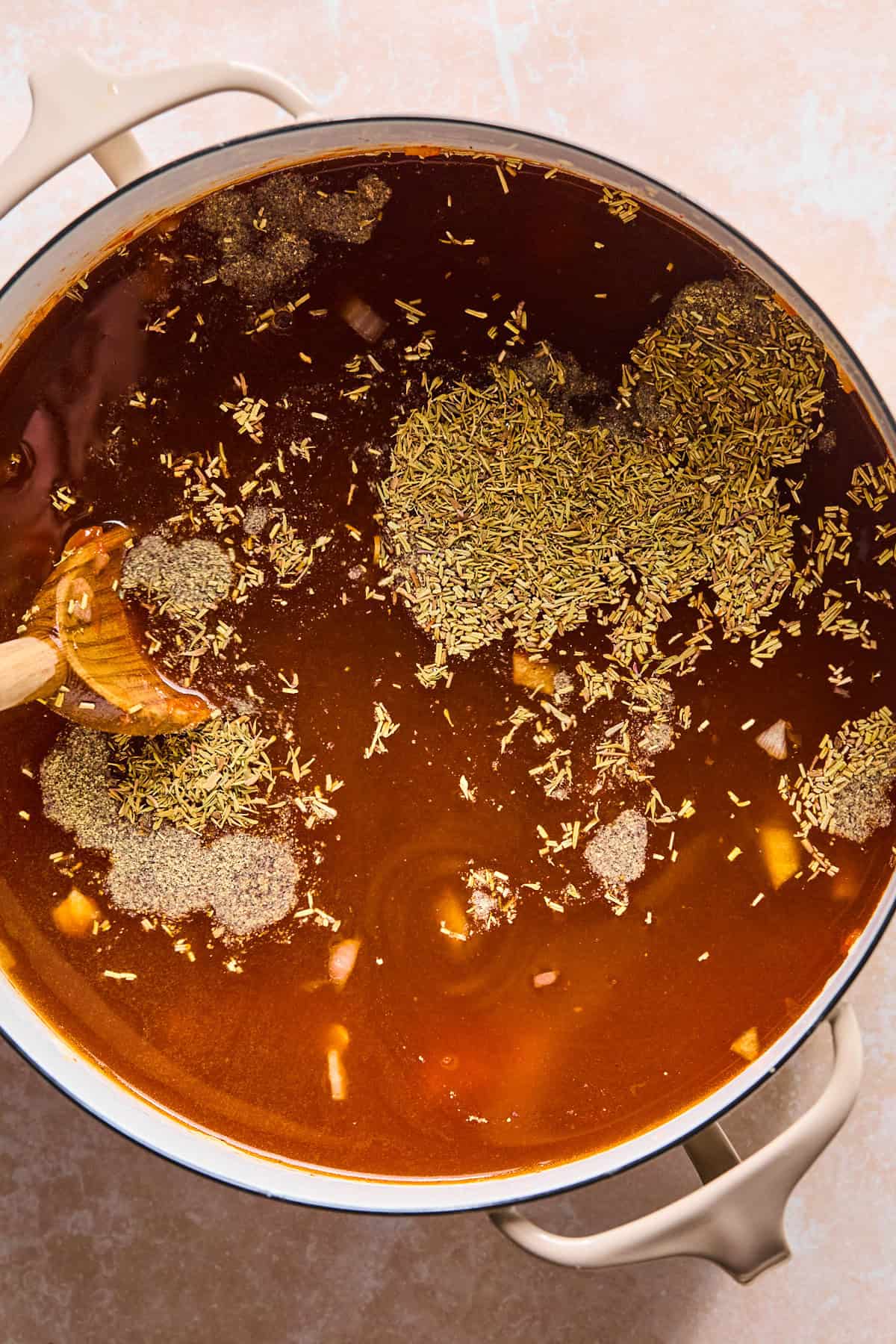 Broth, herbs, and potatoes added to the pot.