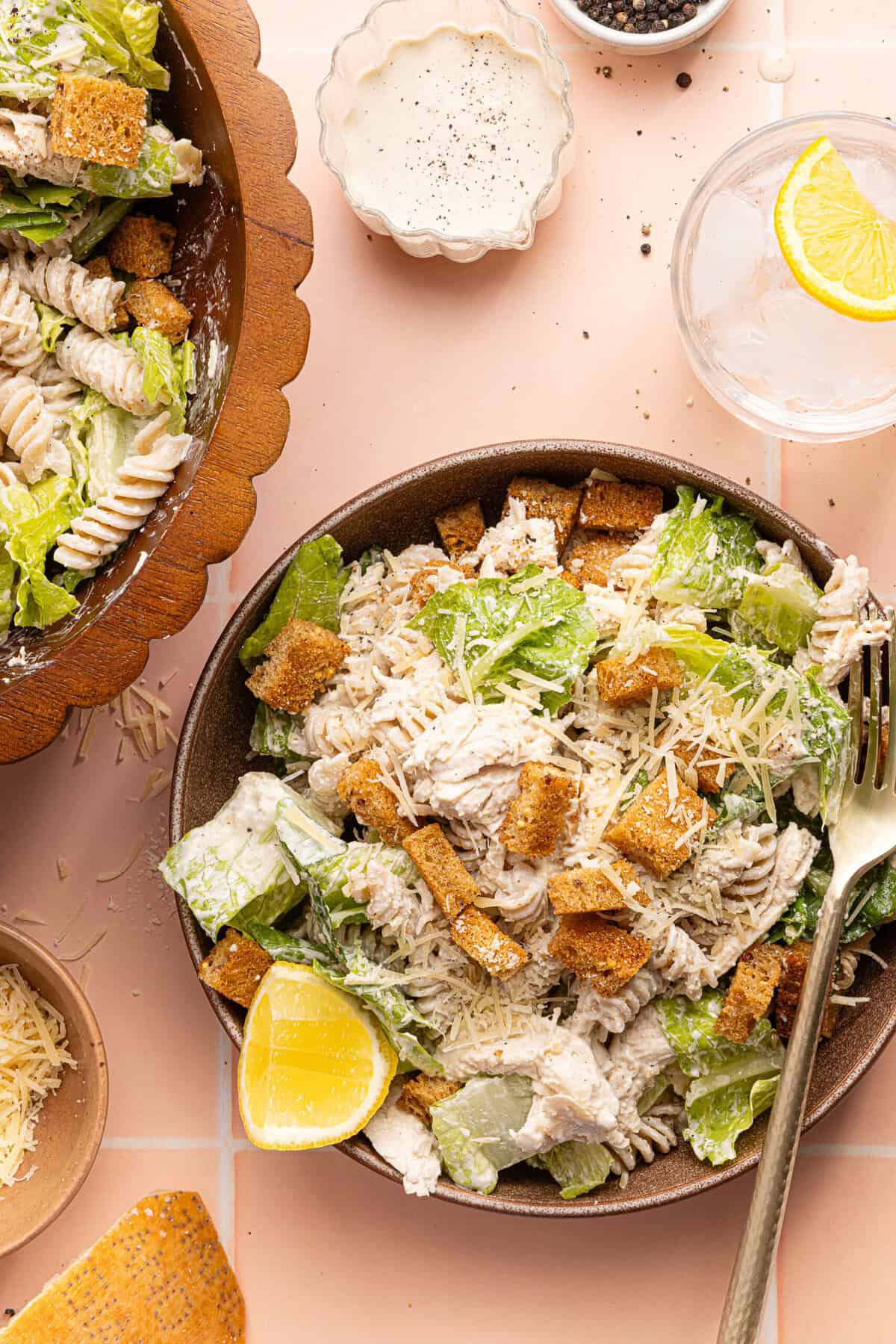 chicken caesar pasta salad in a bowl with a silver fork