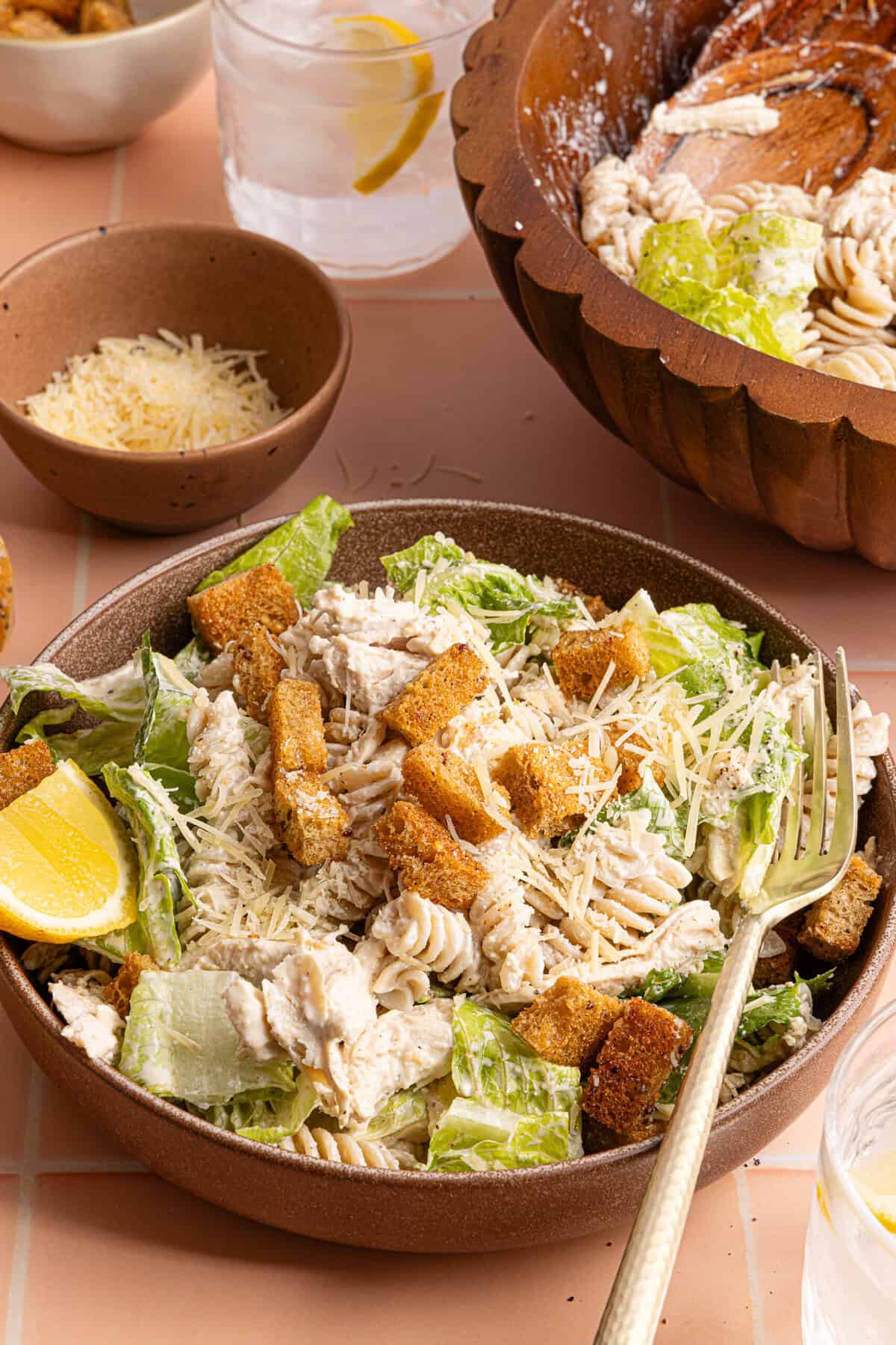 a side view of a bowl of chicken caesar pasta salad