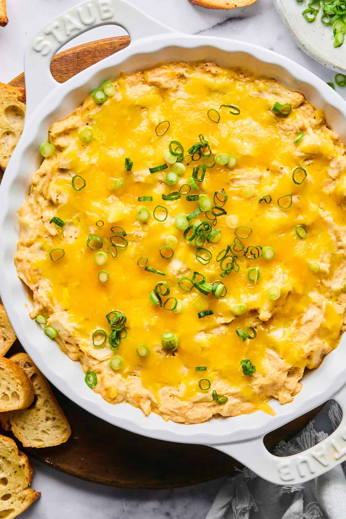Hot crab dip baked until bubbly and golden, topped with green onions and ready to serve.
