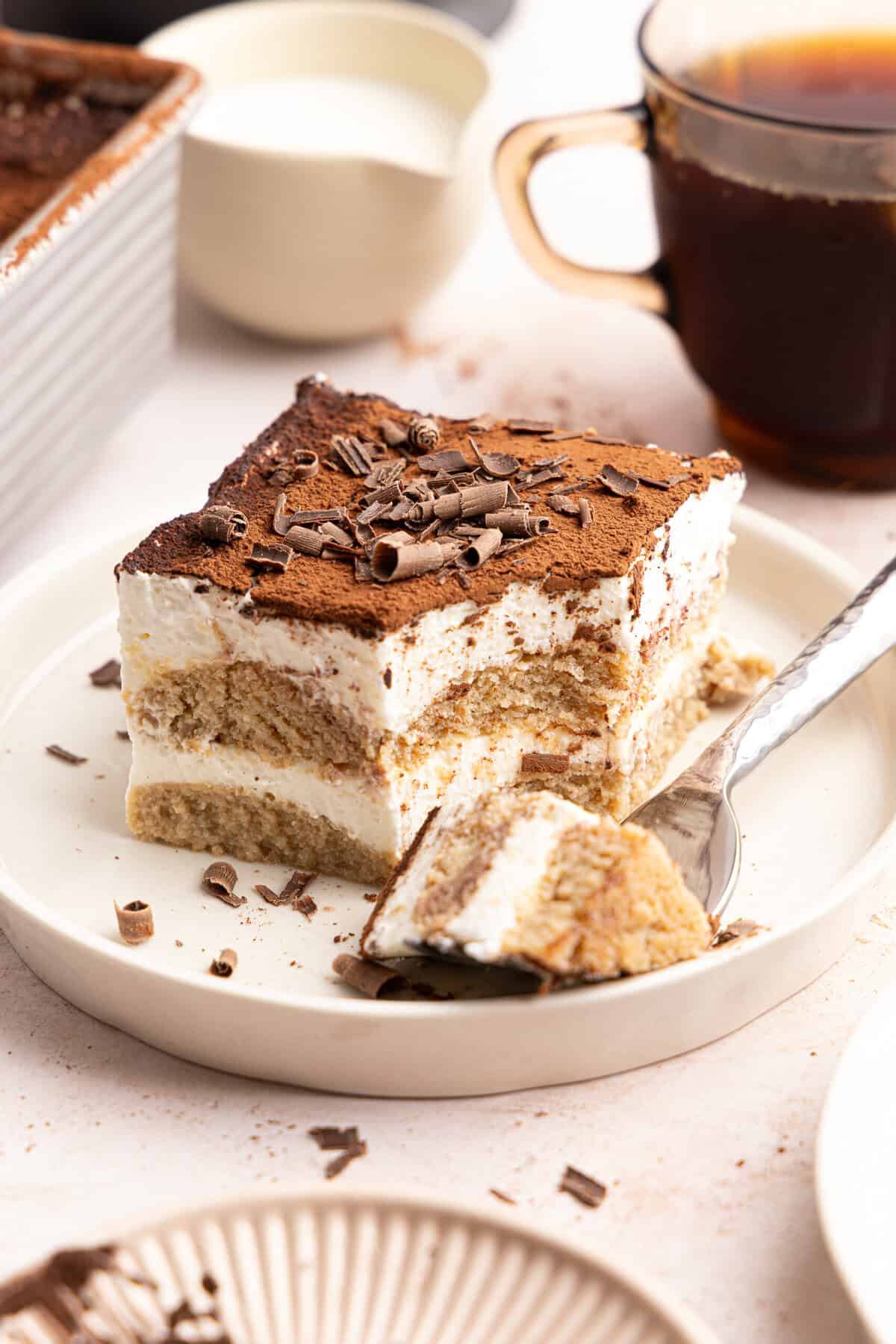 a slice of gluten free tiramisu with a fork taking a bite