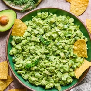 Green goddess chicken salad in a bowl with chips and avocado