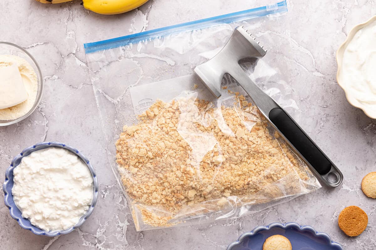 crushed vanilla wafers in a plastic bag with a meat mallet