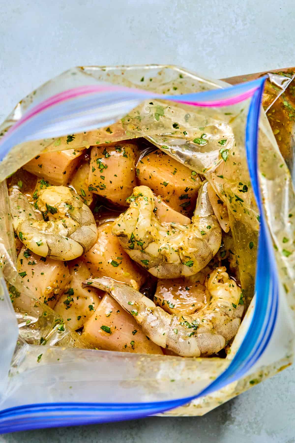 chicken and shrimp marinating in a plastic bag