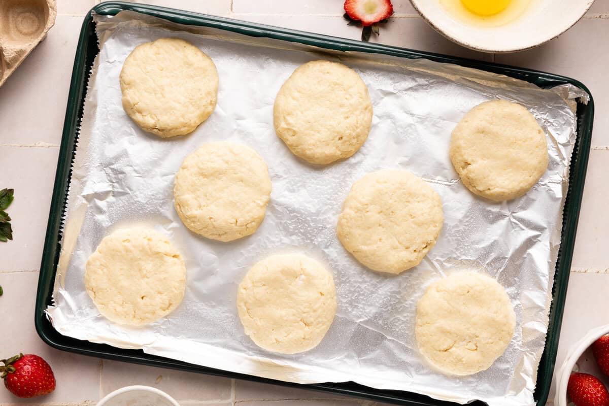 raw biscuits on a foil-lined baking sheet
