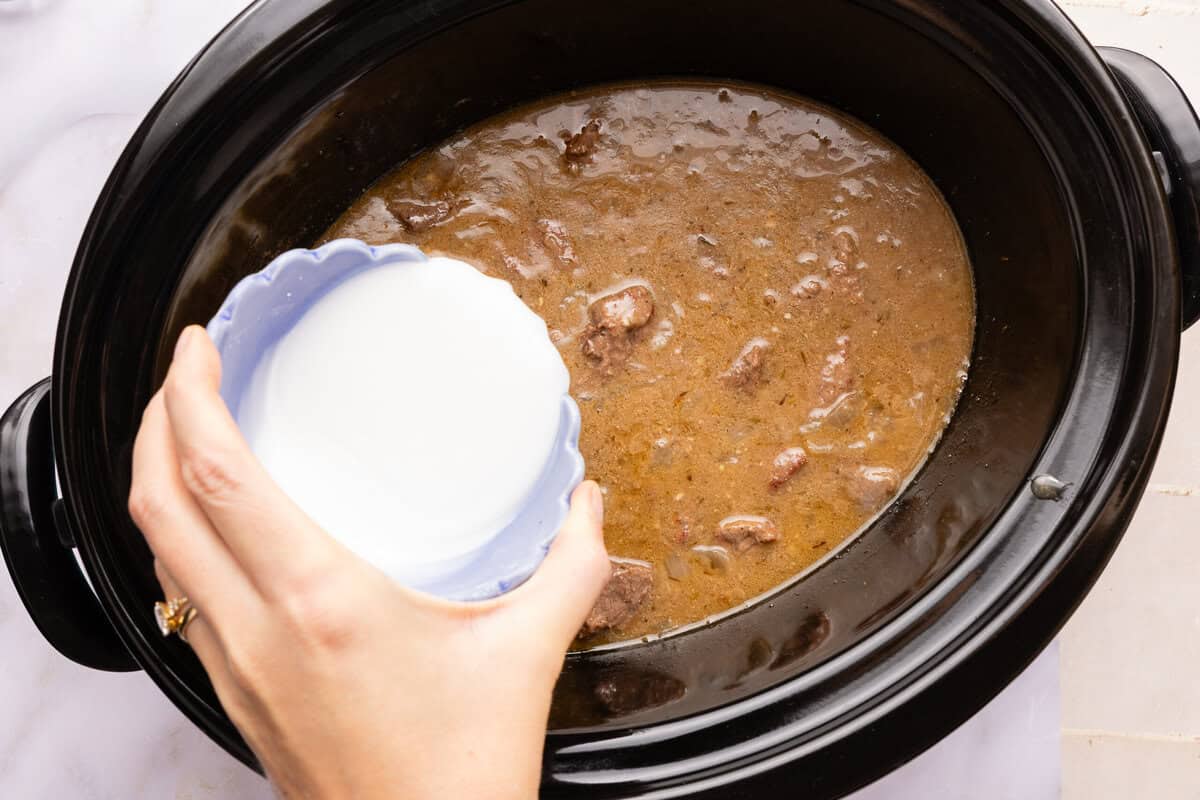 arrowroot slurry being poured into a slow cooker