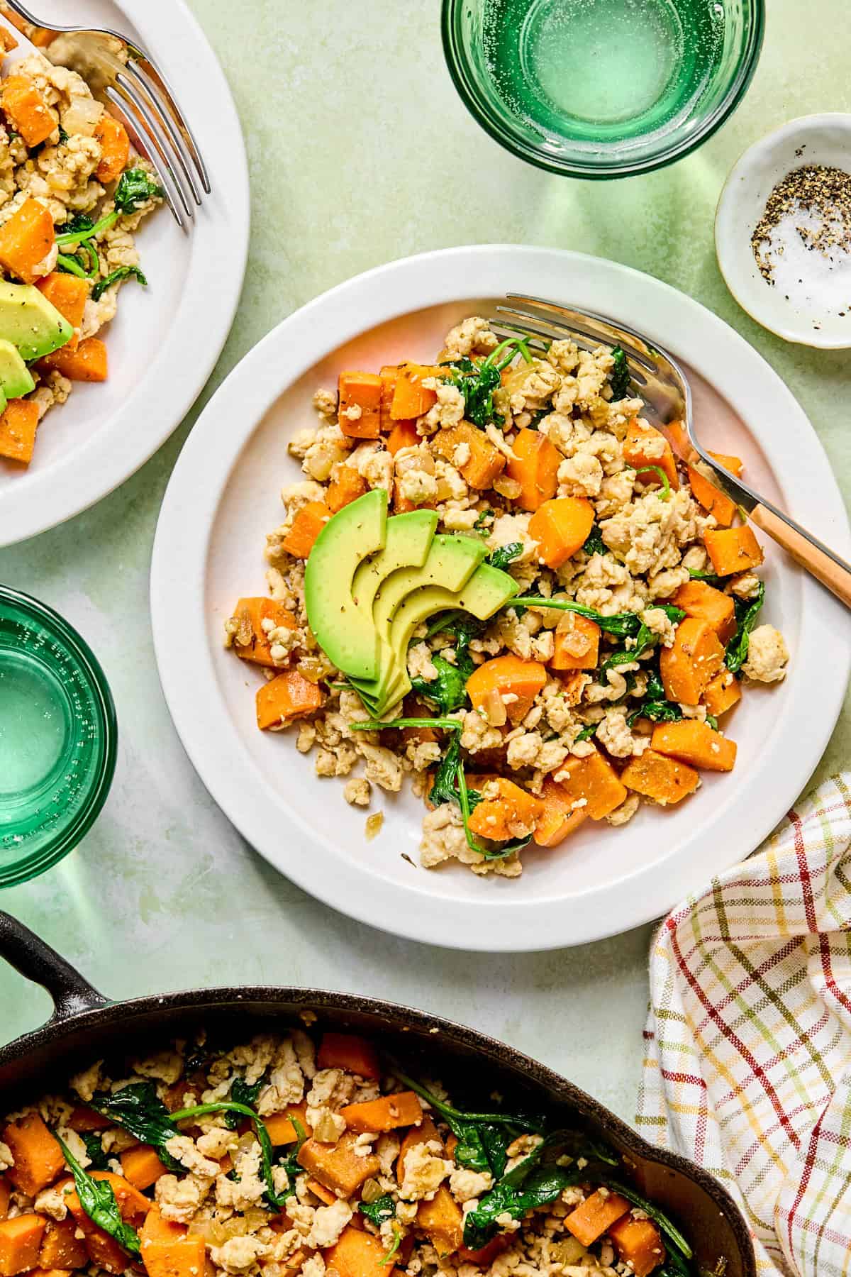 sweet potato breakfast hash in a white bowl next to a skillet