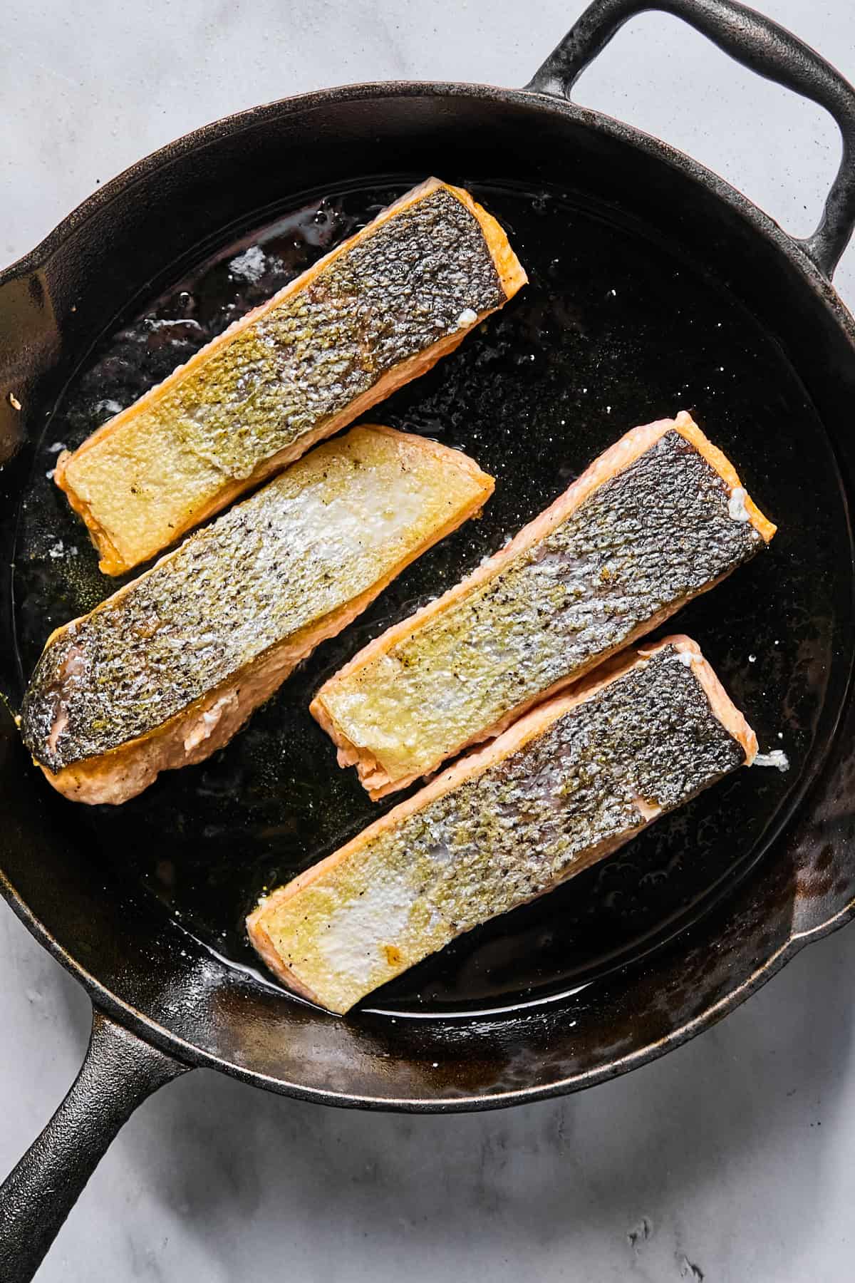 salmon in a cast iron skillet, skin-side up