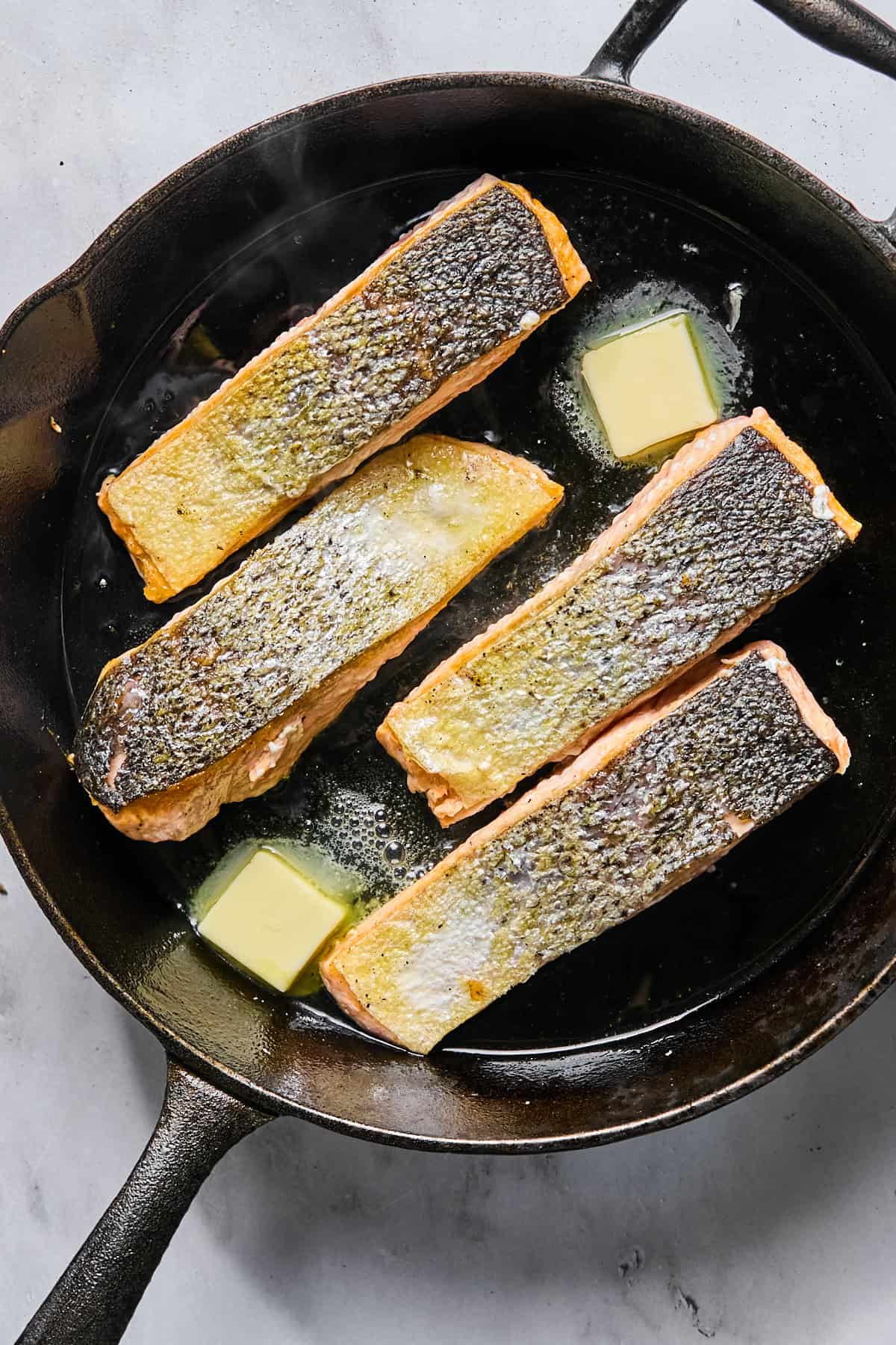 butter in a skillet with 4 salmon fillets