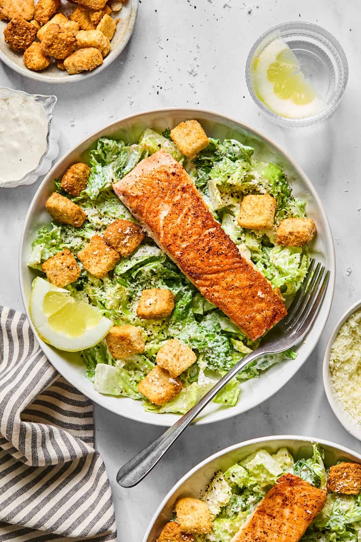 salmon caesar salad in a bowl with croutons