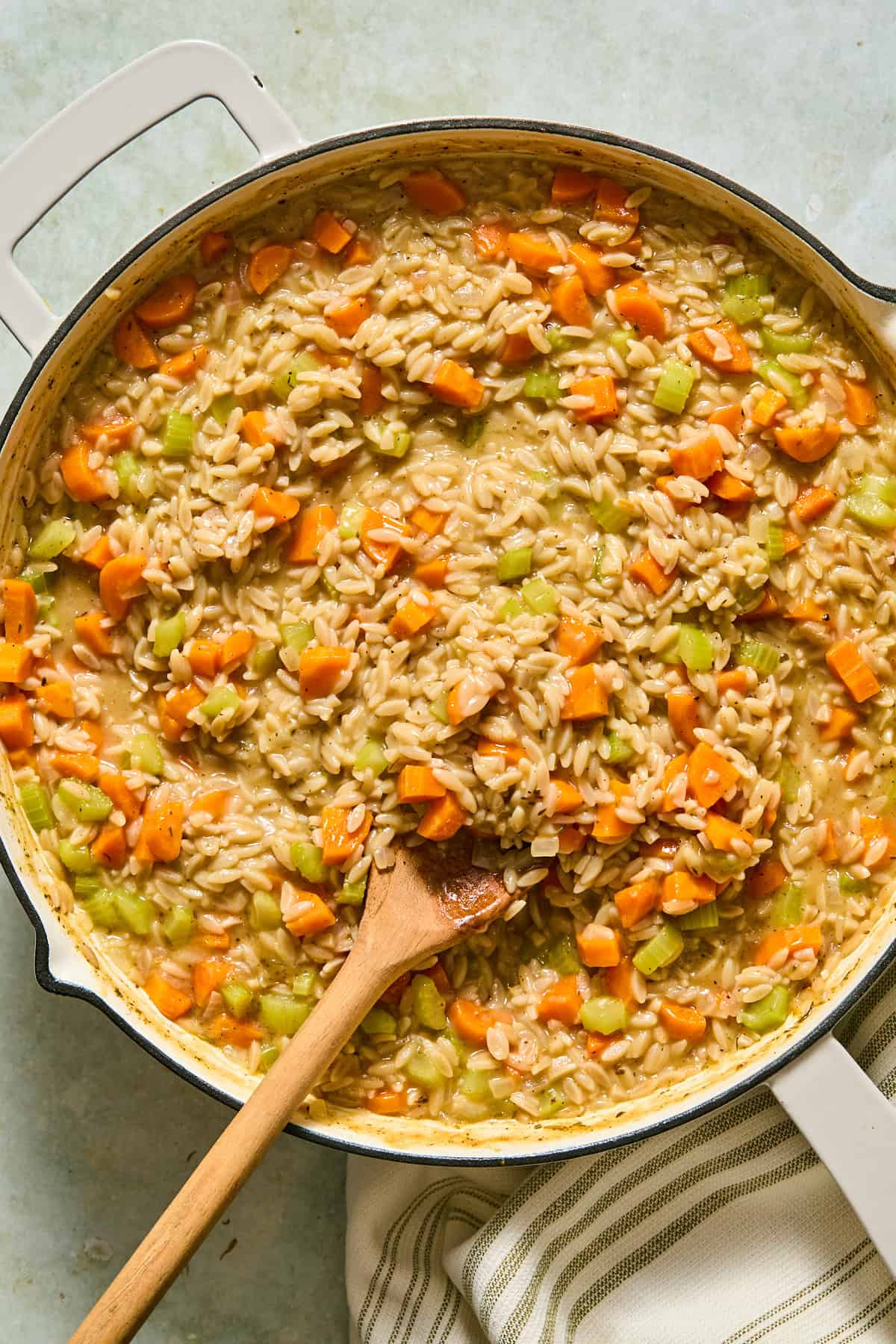 Orzo and vegetables simmering in broth over medium-low heat until the orzo is tender and most of the liquid is absorbed.