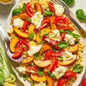 corn, tomato, peach and burrata salad on a platter