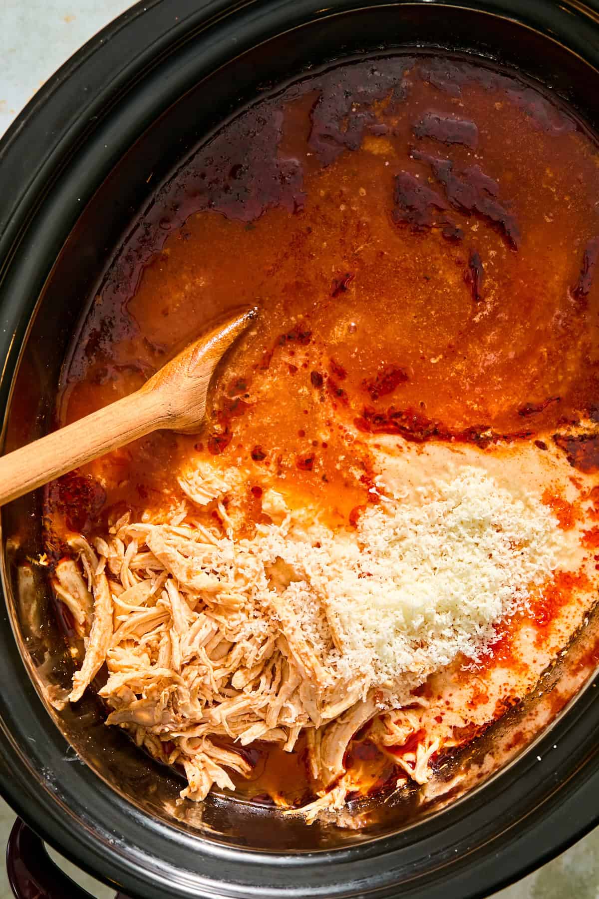 Half and half and grated parmesan stirred into chicken parmesan soup in a slow cooker