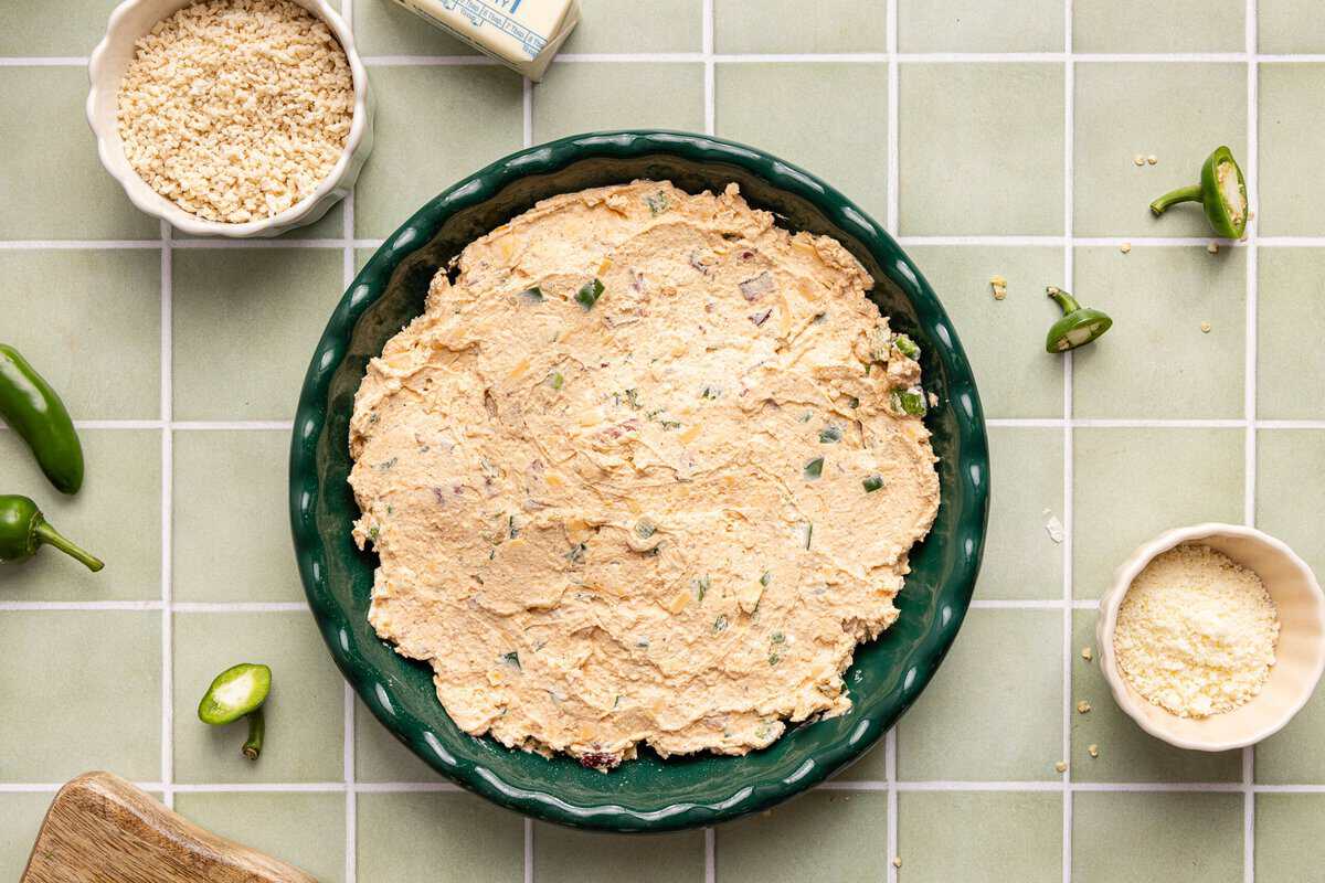 Unbaked jalapeno popper dip in a round dish before topping with toasted panko.