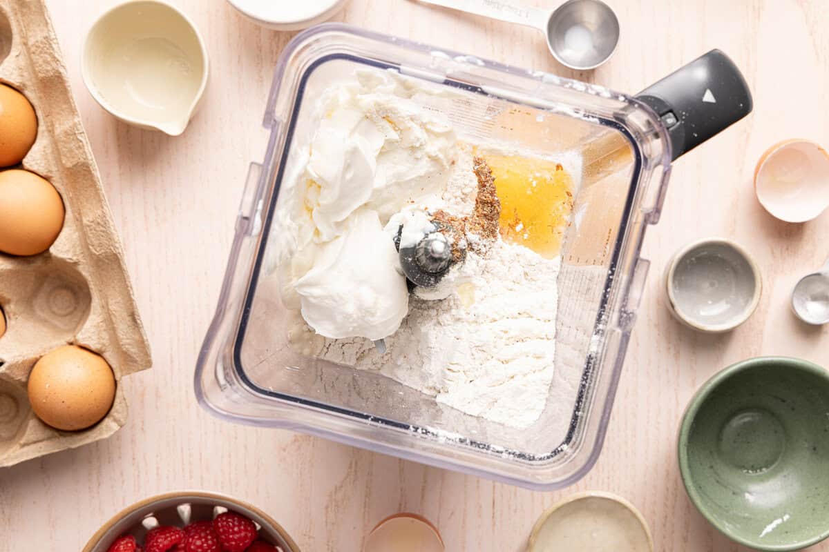 Bird's-eye view of a blender filled with ingredients for protein pancake bowls.