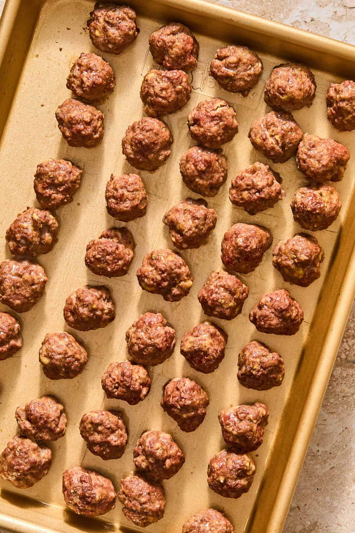 Baked mini meatballs on a sheet pan right out of the oven.