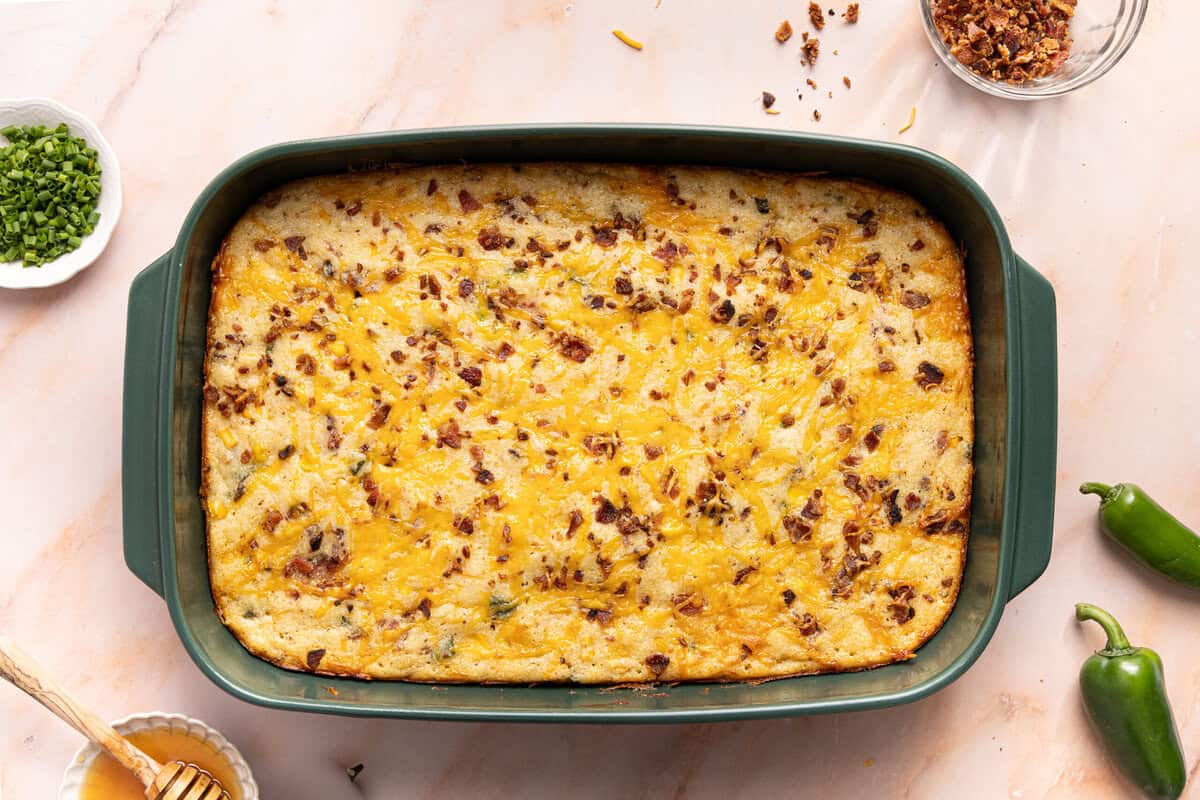 A baked cornbread casserole before topping with jalapeño and hot honey.