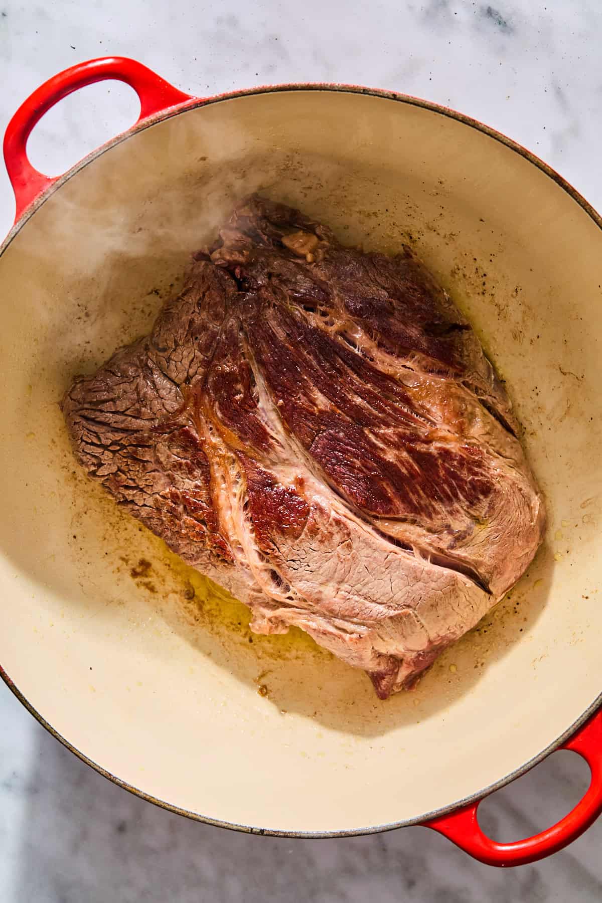 Chuck roast searing in a Dutch oven.