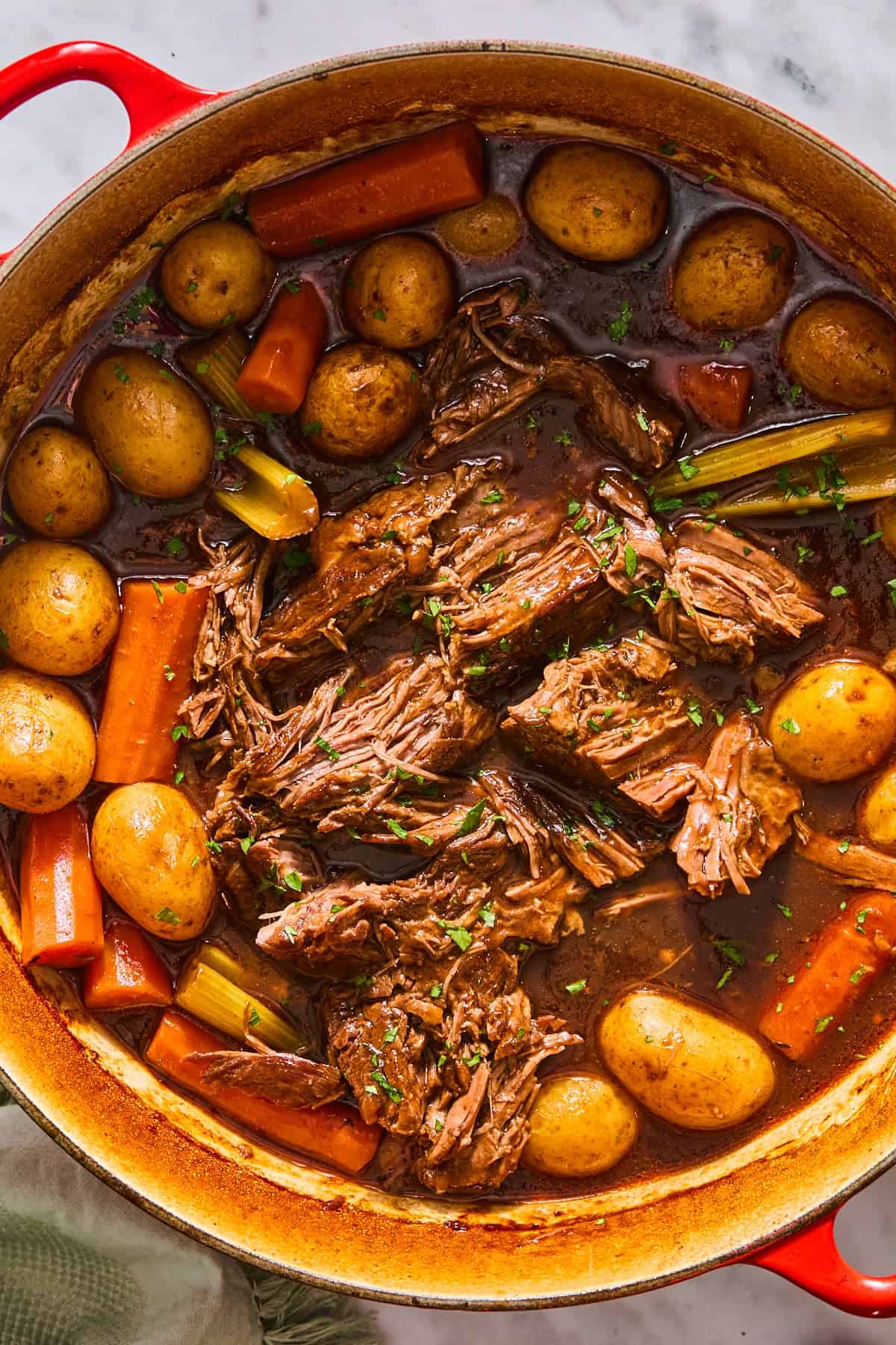 Shredding the beef in the pot roast before serving.